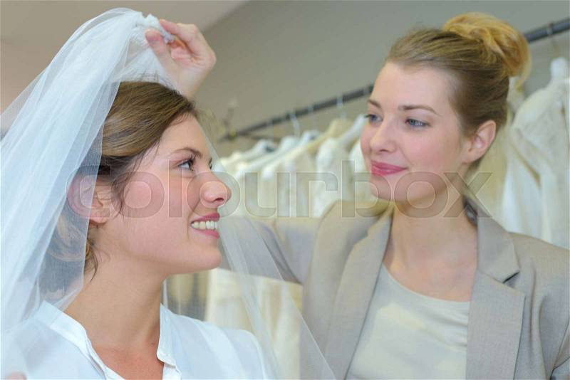 Woman being fitted with wedding veil, stock photo