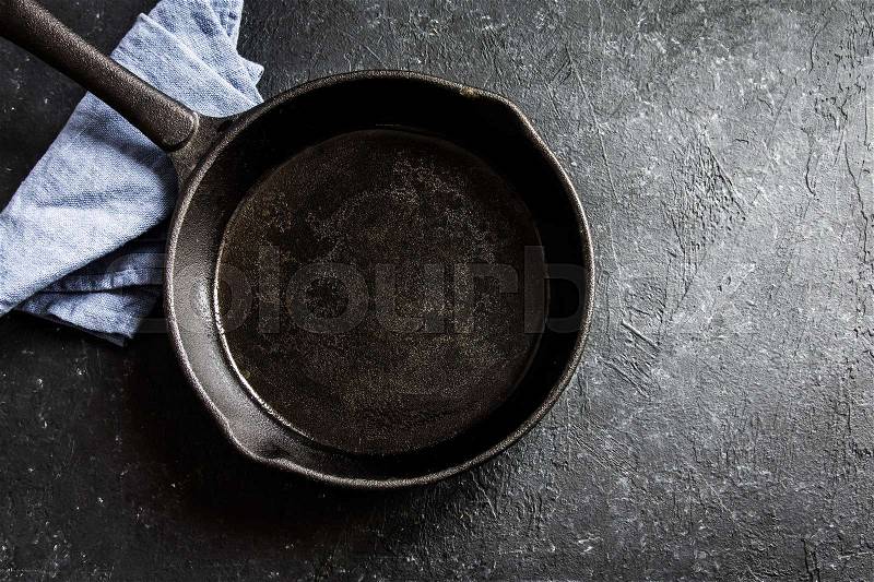 Cast iron pan on rustic black stone background close up - empty black frying pan frying skillet with copy space , stock photo