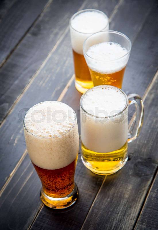 Beer glasses with various beer on old wood table, stock photo