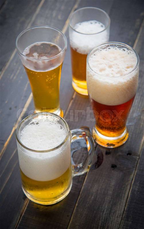 Beer glasses with various beer on old wood table, stock photo