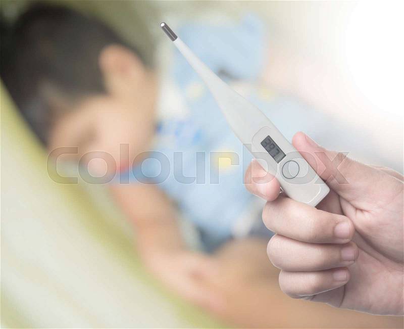 Holding electronic thermometer on background of sick children, stock photo