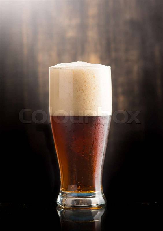 Glass of dark beer over on dark wooden background, stock photo