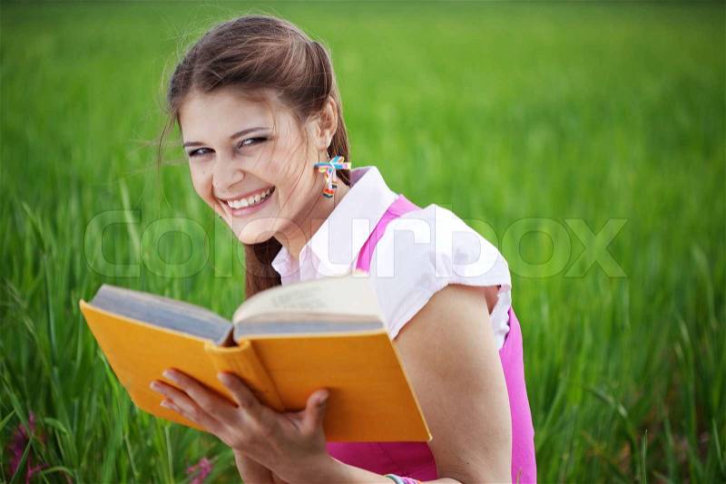 Student girl resting in summer field, stock photo