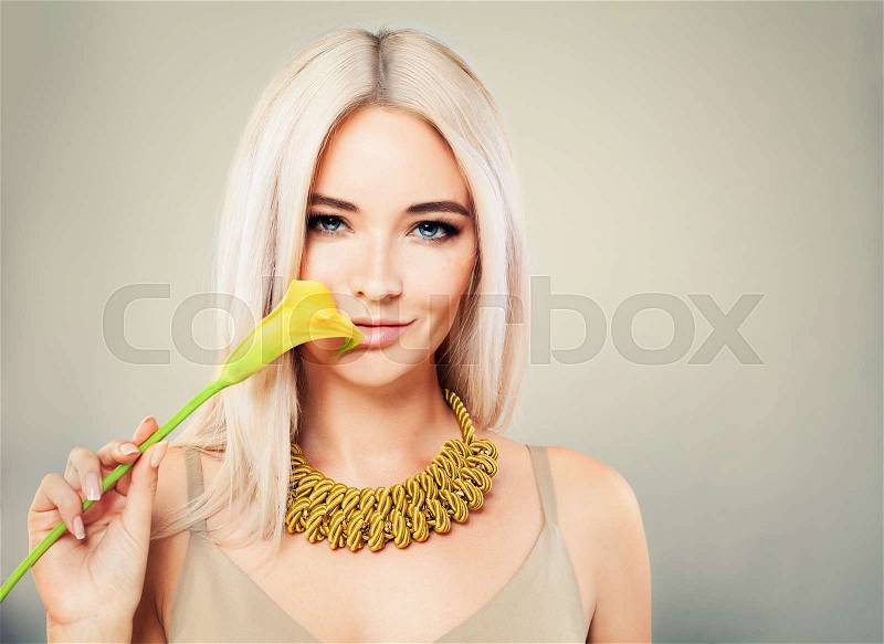 Gorgeous Woman with Blonde Hair. Makeup, Flower and Blonde Hairstyle, stock photo