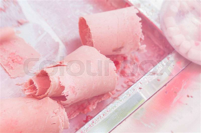 Stir-fried ice cream rolls at freeze pan. Rolled ice cream, handmade dessert from milk, chocolate and fresh strawberry, stock photo