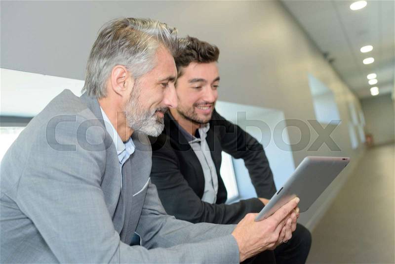Two men and a tablet, stock photo