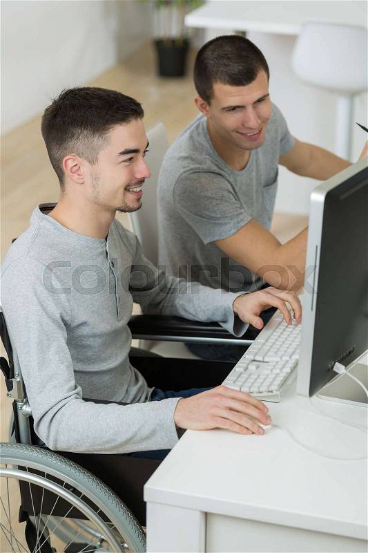 Two young men in front of the computer, stock photo