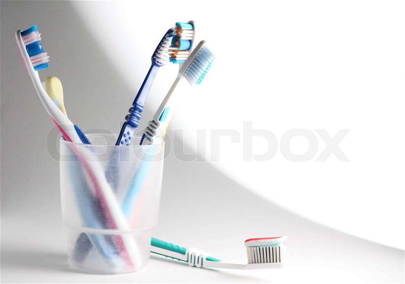 Some toothbrushes in a plastic glass, stock photo