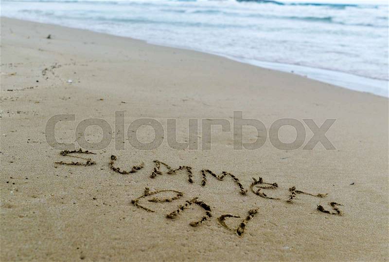 Closeup of the text summers end carved in the sand of a beach, stock photo
