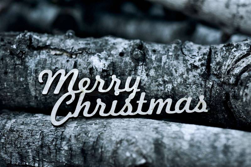 The text merry christmas on a pile of logs, stock photo