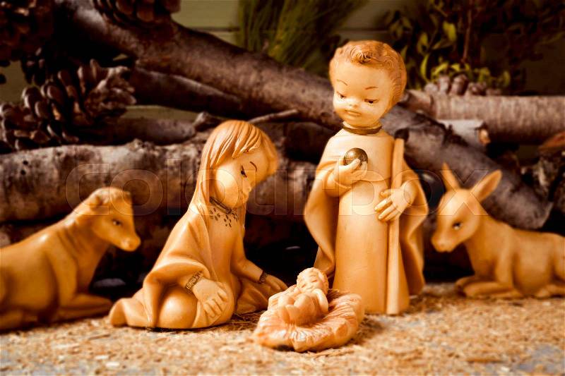 The holy family, the Child Jesus, the Virgin Mary and Saint Joseph, and the donkey and the ox in a rustic nativity scene, stock photo