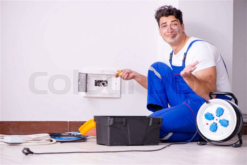 Funny Man doing electrical repairs at home, stock photo