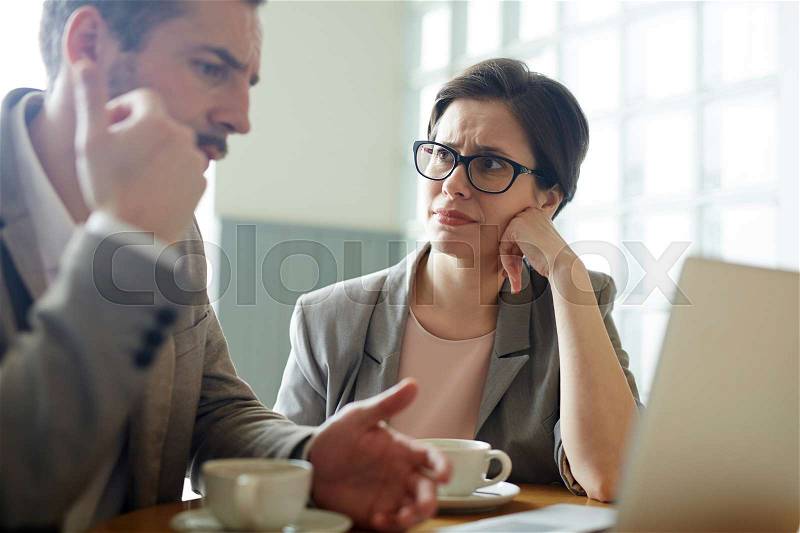 Portrait of two confused business people, man and woman, solving work problem during meeting in cafe, stock photo
