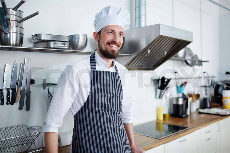 Smiling chef in the kitchen of his own bakery, stock photo
