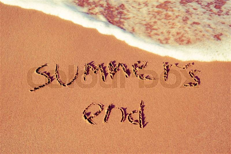 The text summers end written in the sand of a beach, stock photo