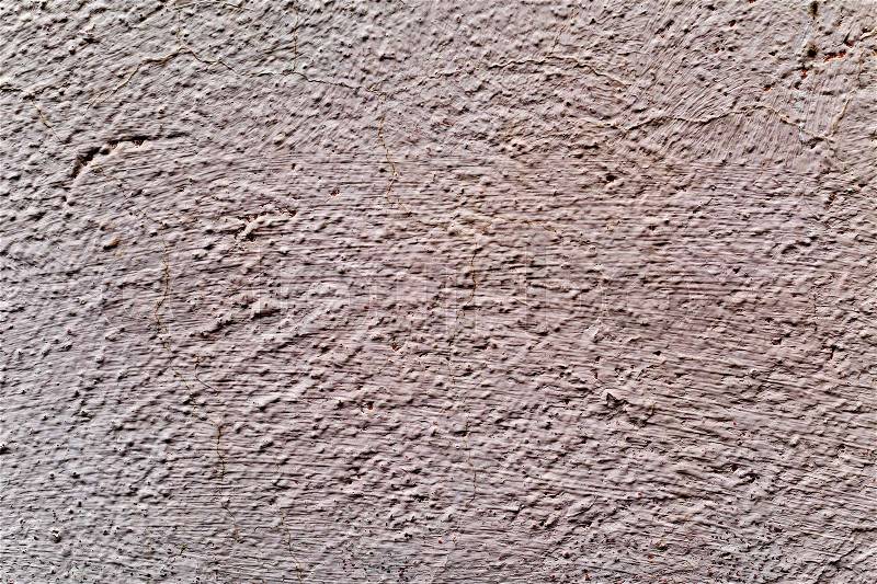 Closeup of a rustic beige plastered wall to be used as a texture or a background, stock photo