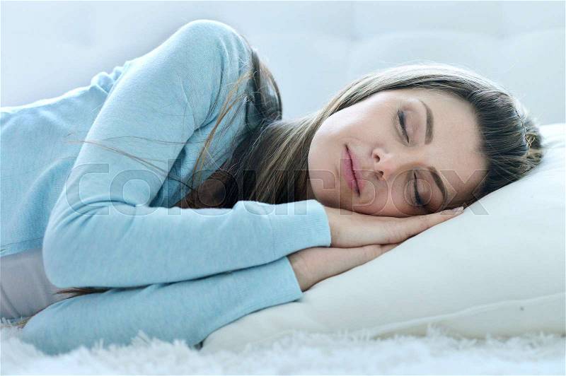 Portrait of a beautiful young woman sleeping on pillow, stock photo