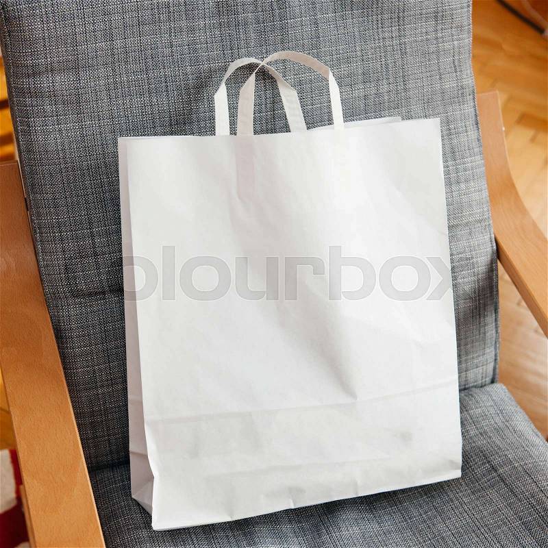 White fashion bag with logo copy space on armchair, stock photo