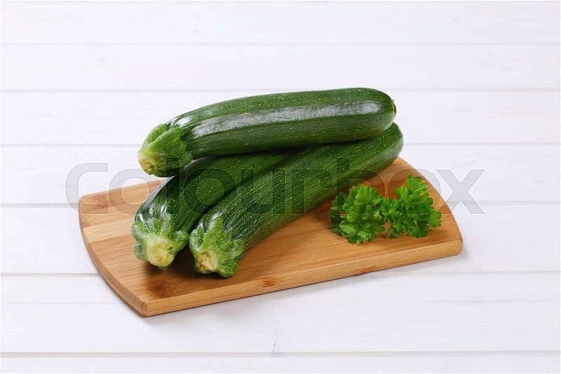 Fresh green zucchini on wooden cutting board, stock photo