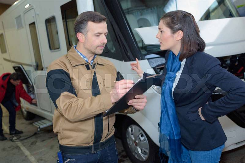 Male renting agent checking car state with female customer, stock photo