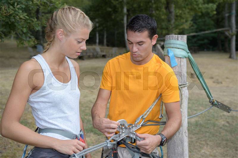 Pretty female learning security rules at the adventure park, stock photo