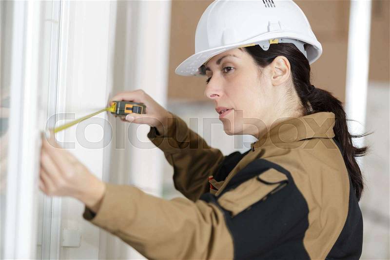 Female worker measure furniture with measuring tape, stock photo