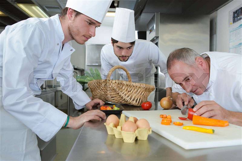 Team of chefs and cooks in restaurant kitchen, stock photo