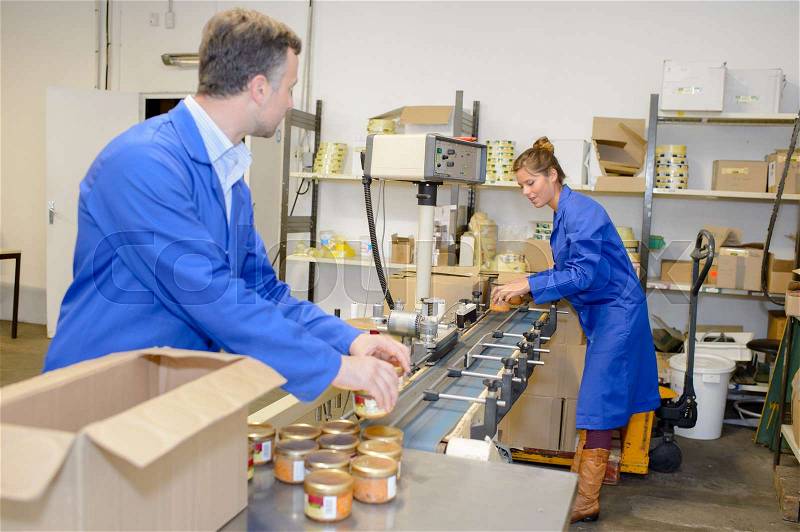 Canned food factory workers at work, stock photo