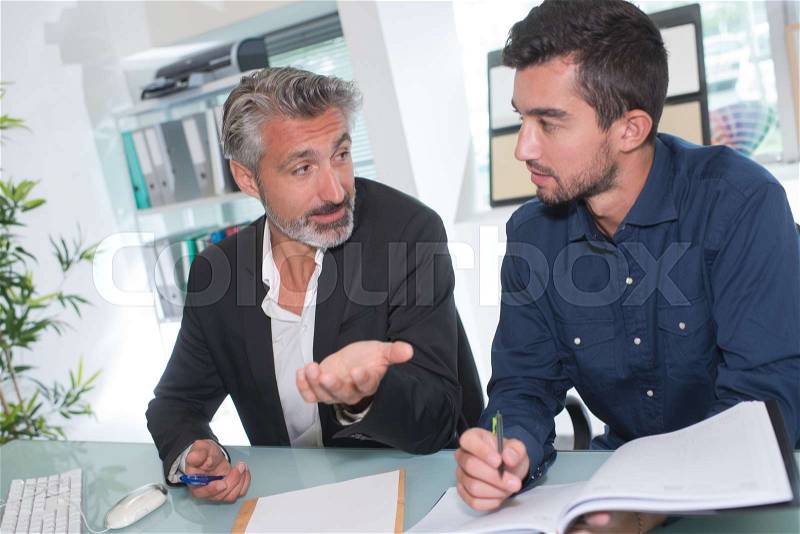 Businessmen in office working out new plan for future project, stock photo