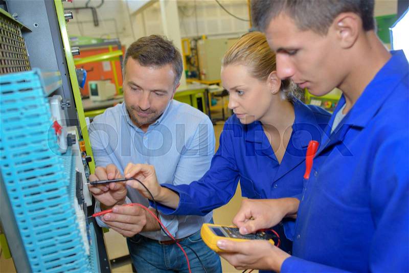 Electrician explaining trainees building electric plan, stock photo
