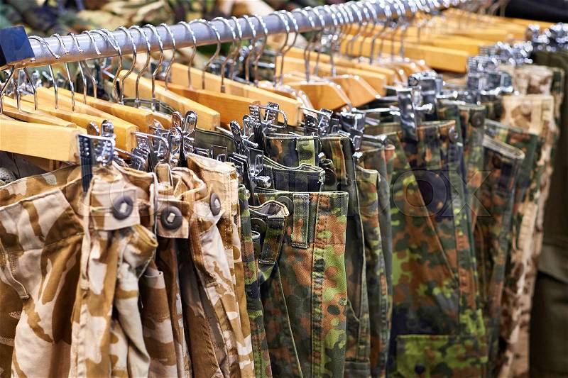 Clothing for hunting and fishing on the hanger in the store, stock photo