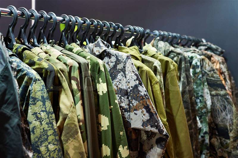 Jackets for hunting and fishing on the hanger in the store, stock photo