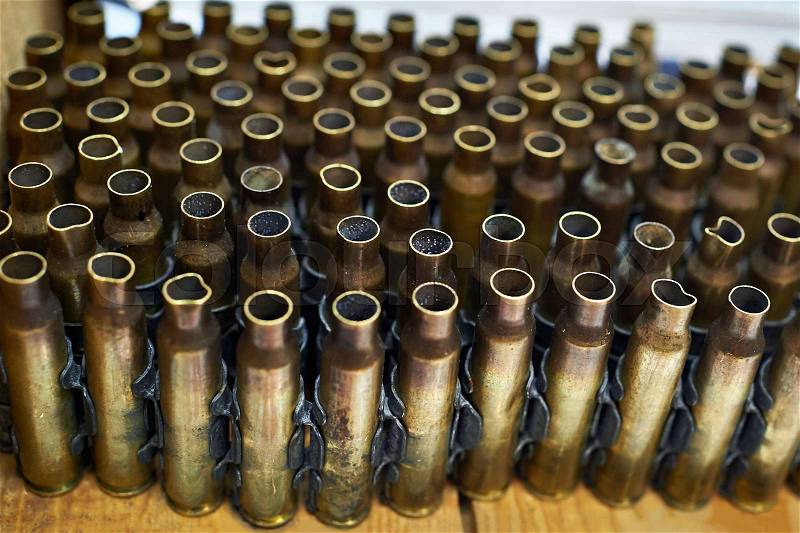 Brass cases of cartridges in a machine-gun tape, stock photo