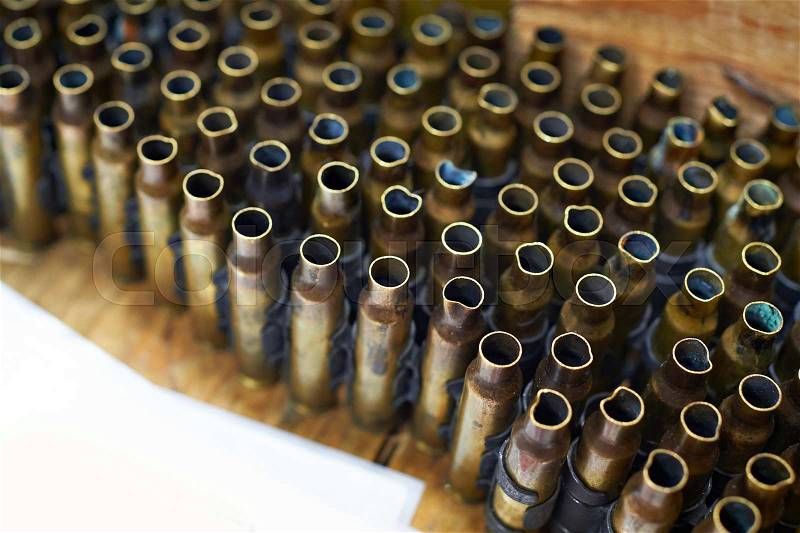 Brass cases of cartridges in a machine-gun tape, stock photo