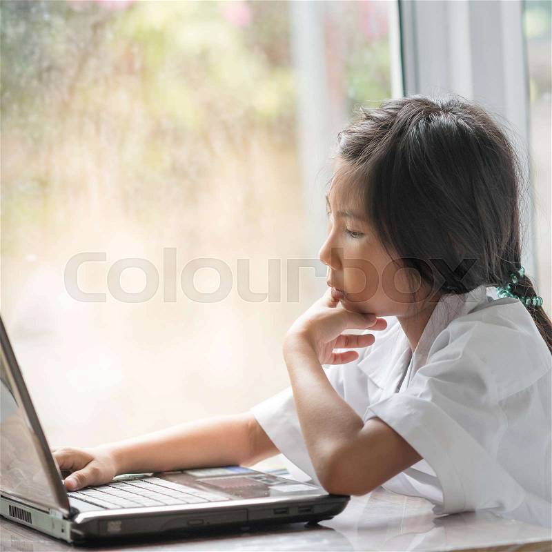Girl Using Laptop near window at home, stock photo
