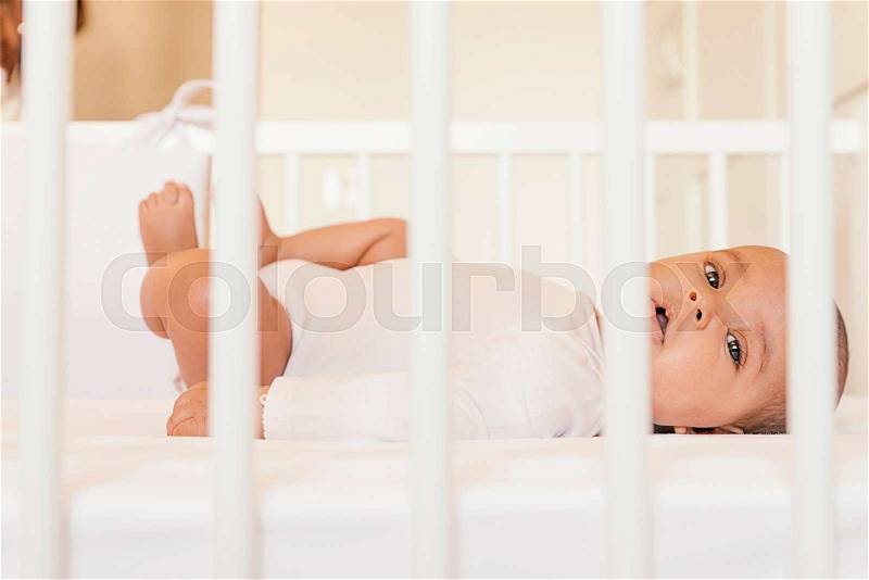 Cute Baby Girl Lying in the Crib. At home, stock photo