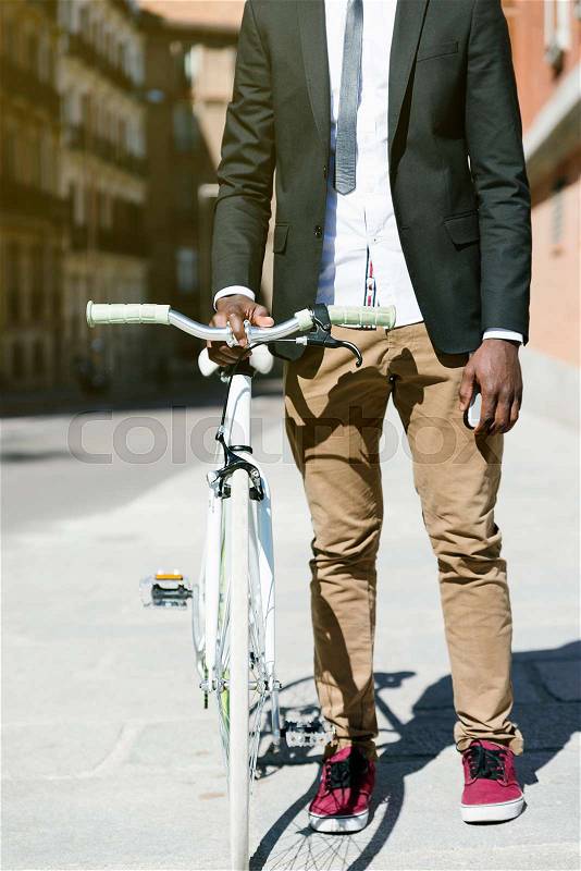 Handsome african man on bike in the city. Bicycle concept, stock photo