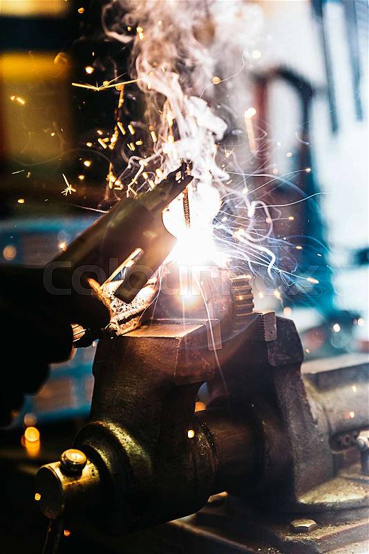 Mechanic man welding metal material in garage. Mechanic Concept, stock photo