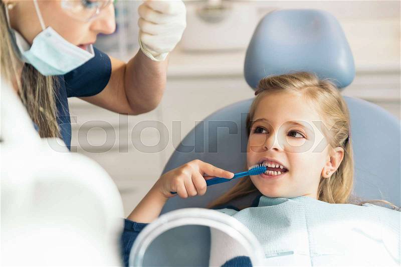 Doctor dentist teaching a child to brush teeth. Dentist concept, stock photo
