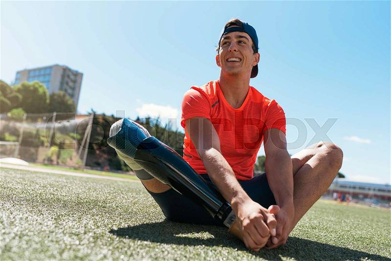Disabled man athlete stretching with leg prosthesis. Paralympic Sport Concept, stock photo