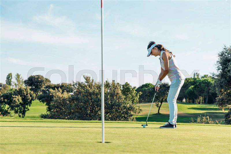 Woman golf player concentrating for putting on green. Golf Concept, stock photo
