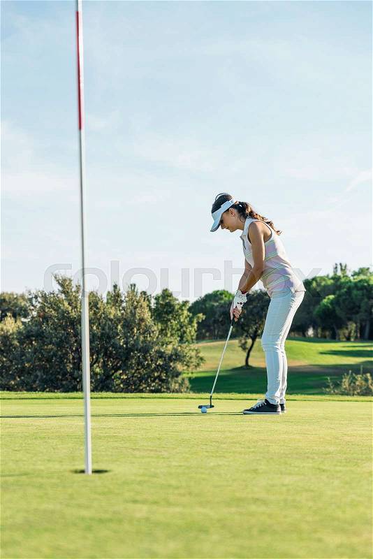 Woman golf player concentrating for putting on green. Golf Concept, stock photo