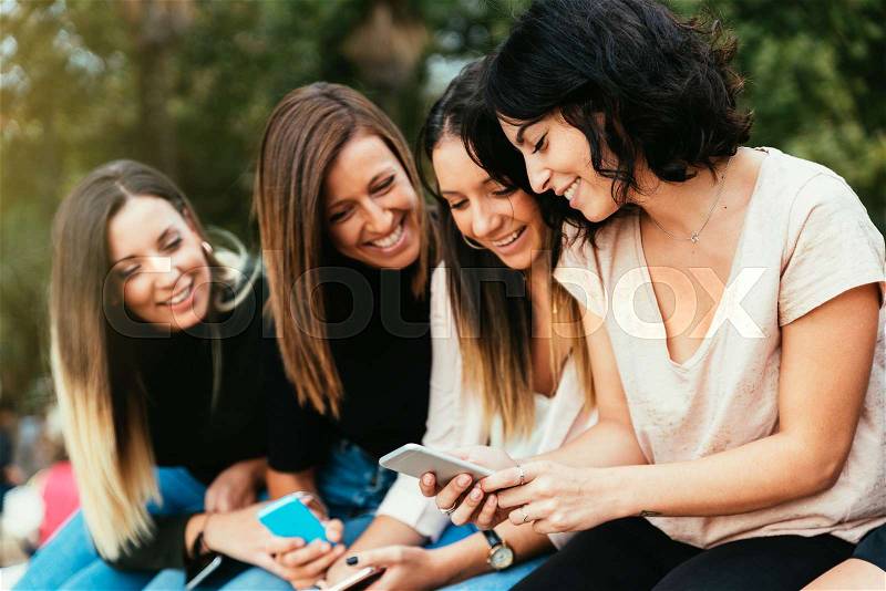 Big Group of friends using cellphones in the street, stock photo
