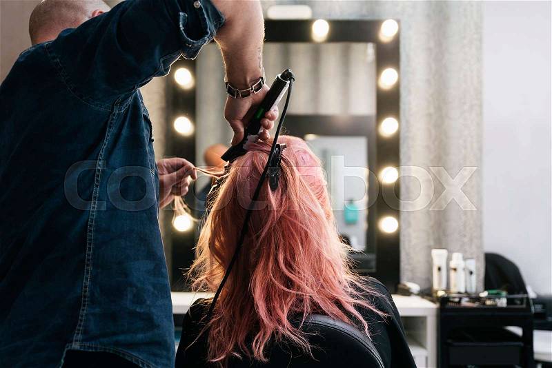 Beautiful woman getting haircut by hairdresser in the beauty salón, stock photo