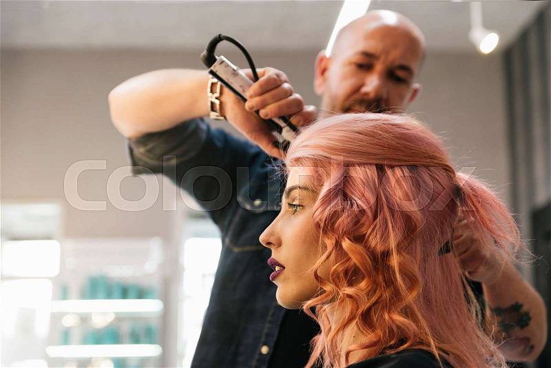 Beautiful woman getting haircut by hairdresser in the beauty salón, stock photo