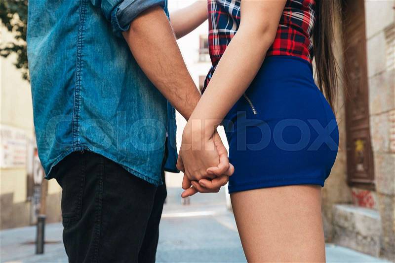 Concept shot of friendship and love of man and woman: two hands over street urban. they are young, stock photo
