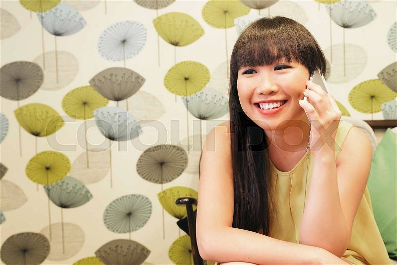 Bar smart casual young asian woman talking on smartphone. Happy female adult speaking on mobile phone, stock photo
