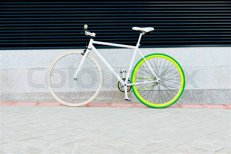 City bicycle fixed gear on wall. Cycling or commuting in city urban environment, ecological transportation concept, stock photo