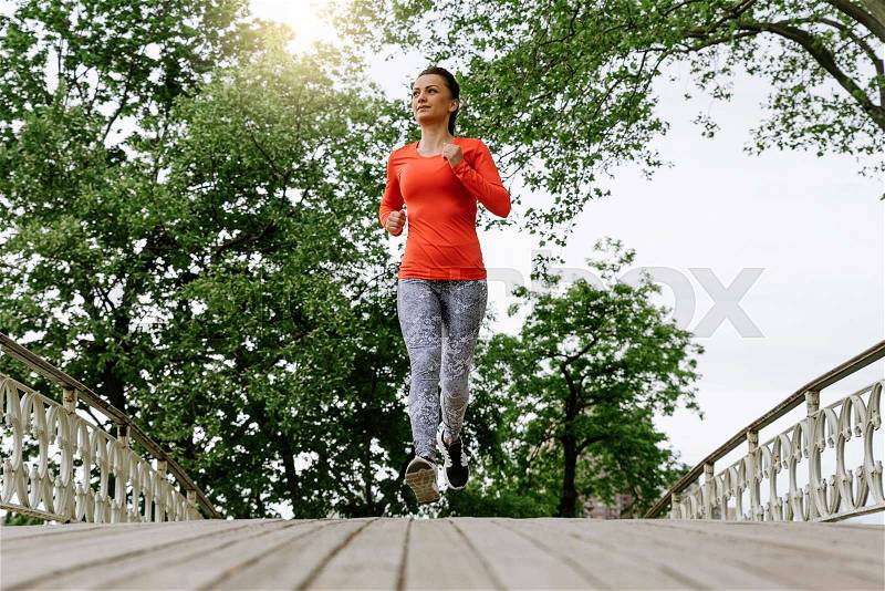 Beautiful young woman running on Central Park, stock photo