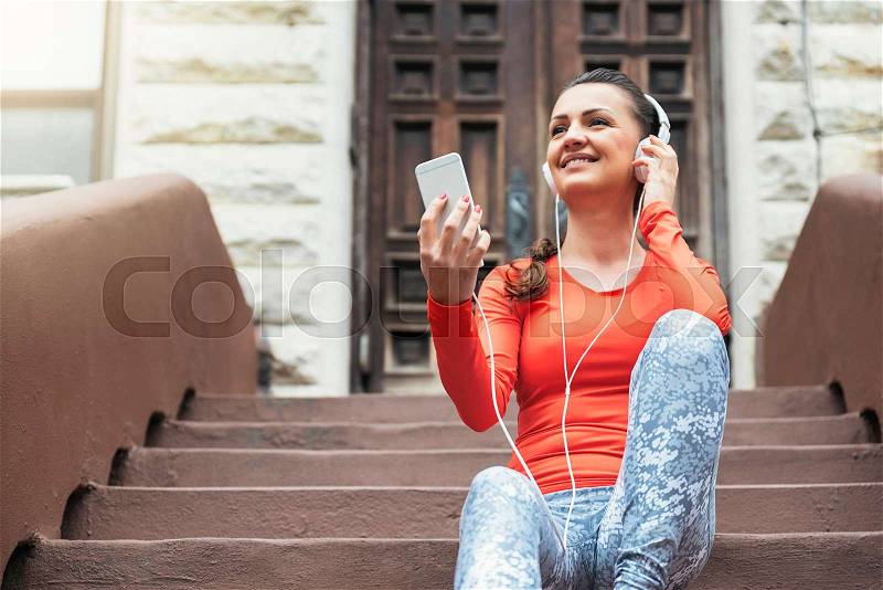 Beautiful woman using phone after running on New York City, stock photo